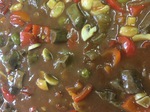 zarte Rindfleischwürfel mit Paprika, Oliven, getrockneten Tomaten, Champignons und Rotwein geschmort